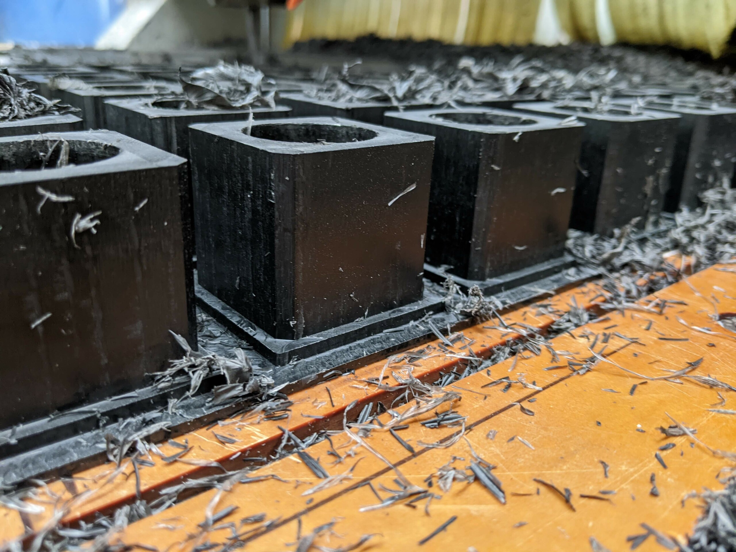 Bung machined from 45mm black acetal. Multiple bungs are machined together out of one large sheet of acetal.