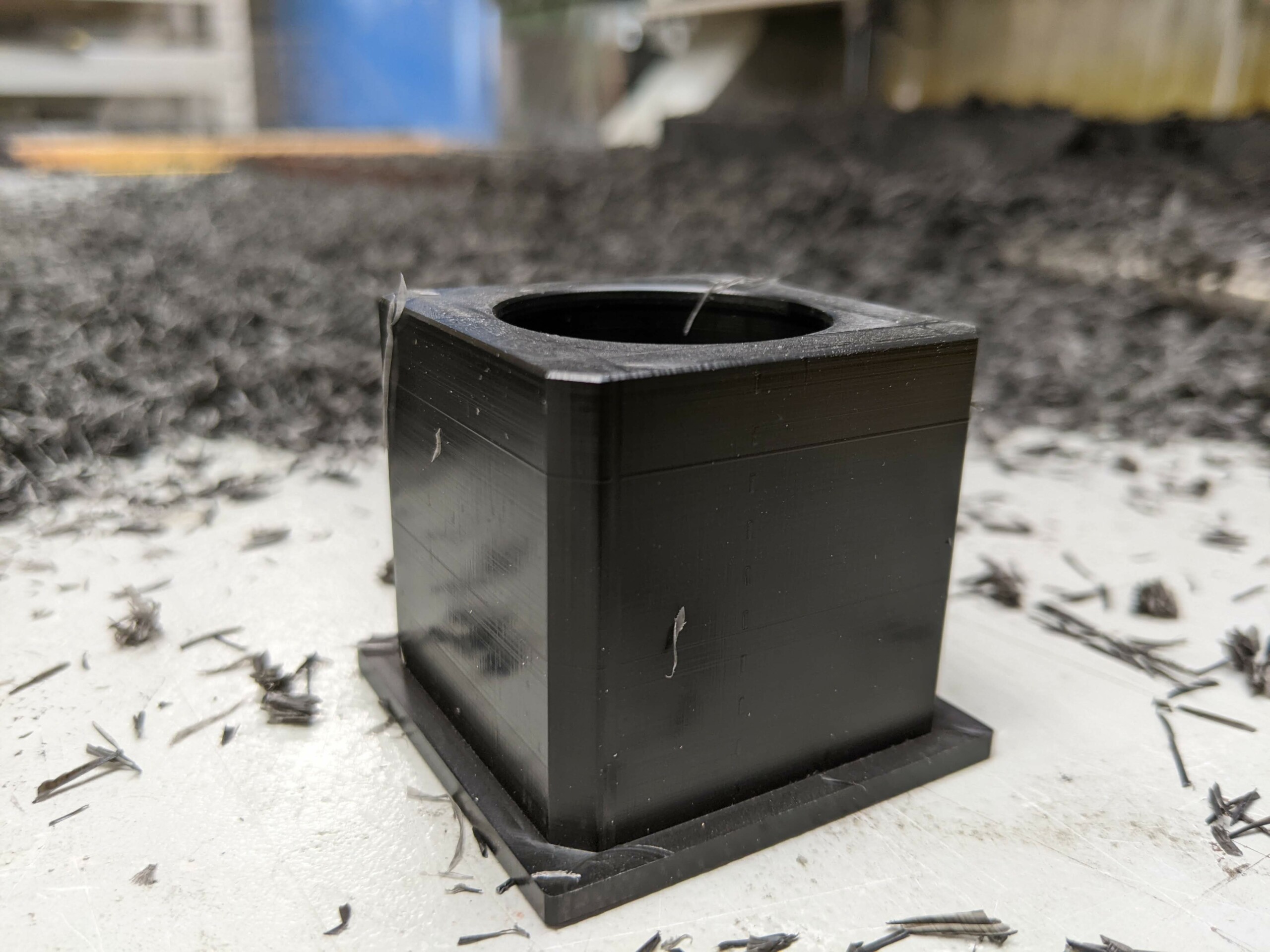 Bung machined from 45mm black acetal. Multiple bungs are machined together out of one large sheet of acetal.